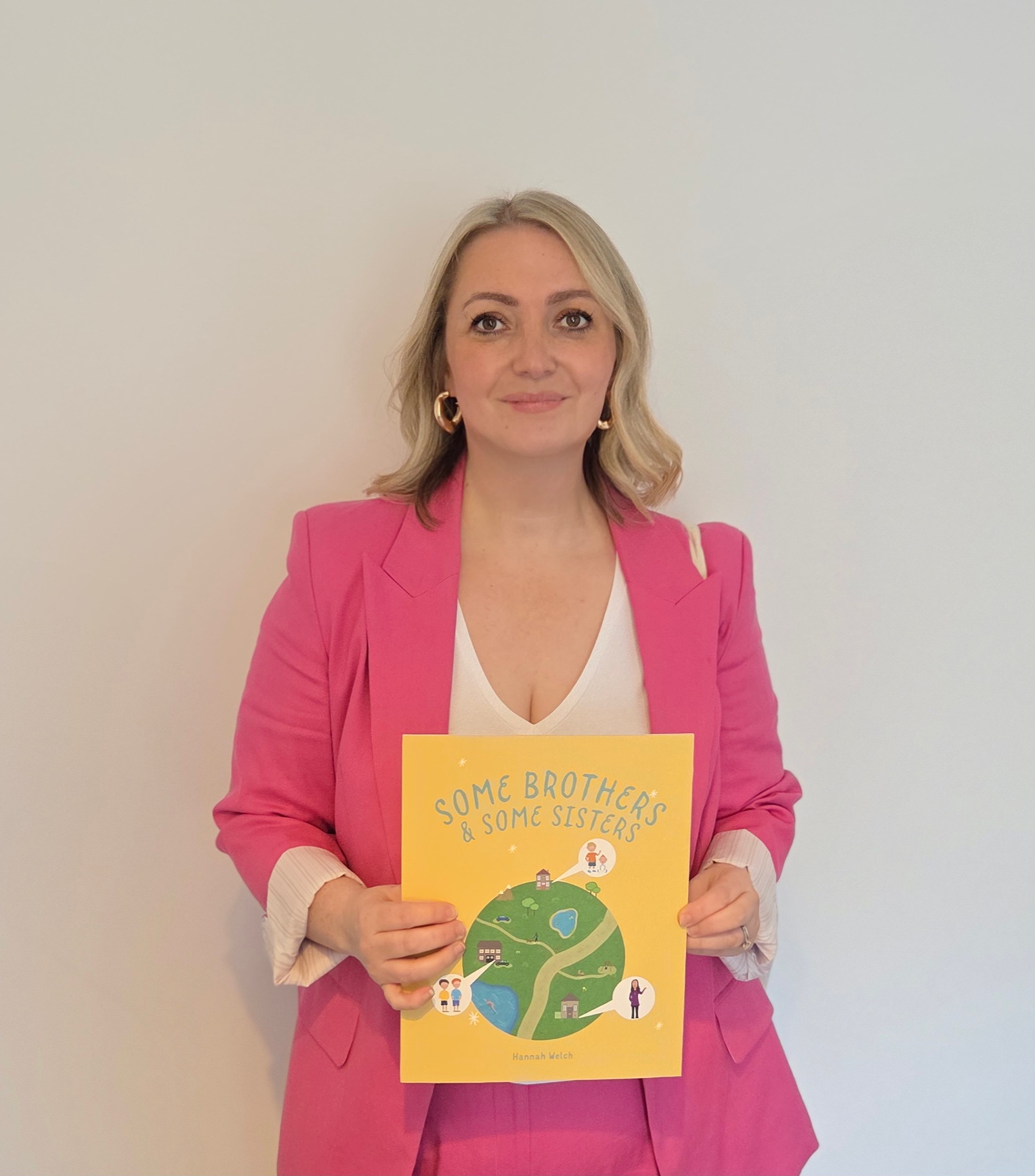 Hannah Welch holding her picture book Some Brothers & Some Sisters